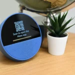 QR code thật bị dán đè bởi QR code giả mạo trên một thiết bị điện tử, minh họa chiêu trò lừa đảo QRishing
