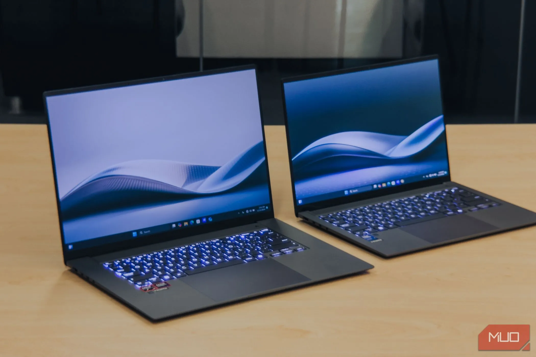 So sánh kích thước ASUS Zenbook S 16 OLED và Zenbook S 14 trên bàn gỗ