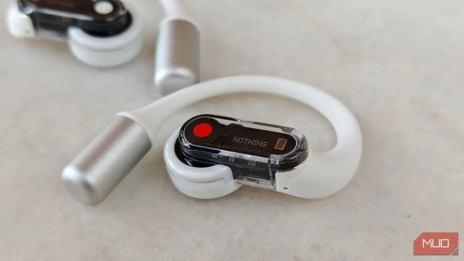 Tai nghe Nothing Ear (open) bên phải cận cảnh, với tai nghe trái ở hậu cảnh