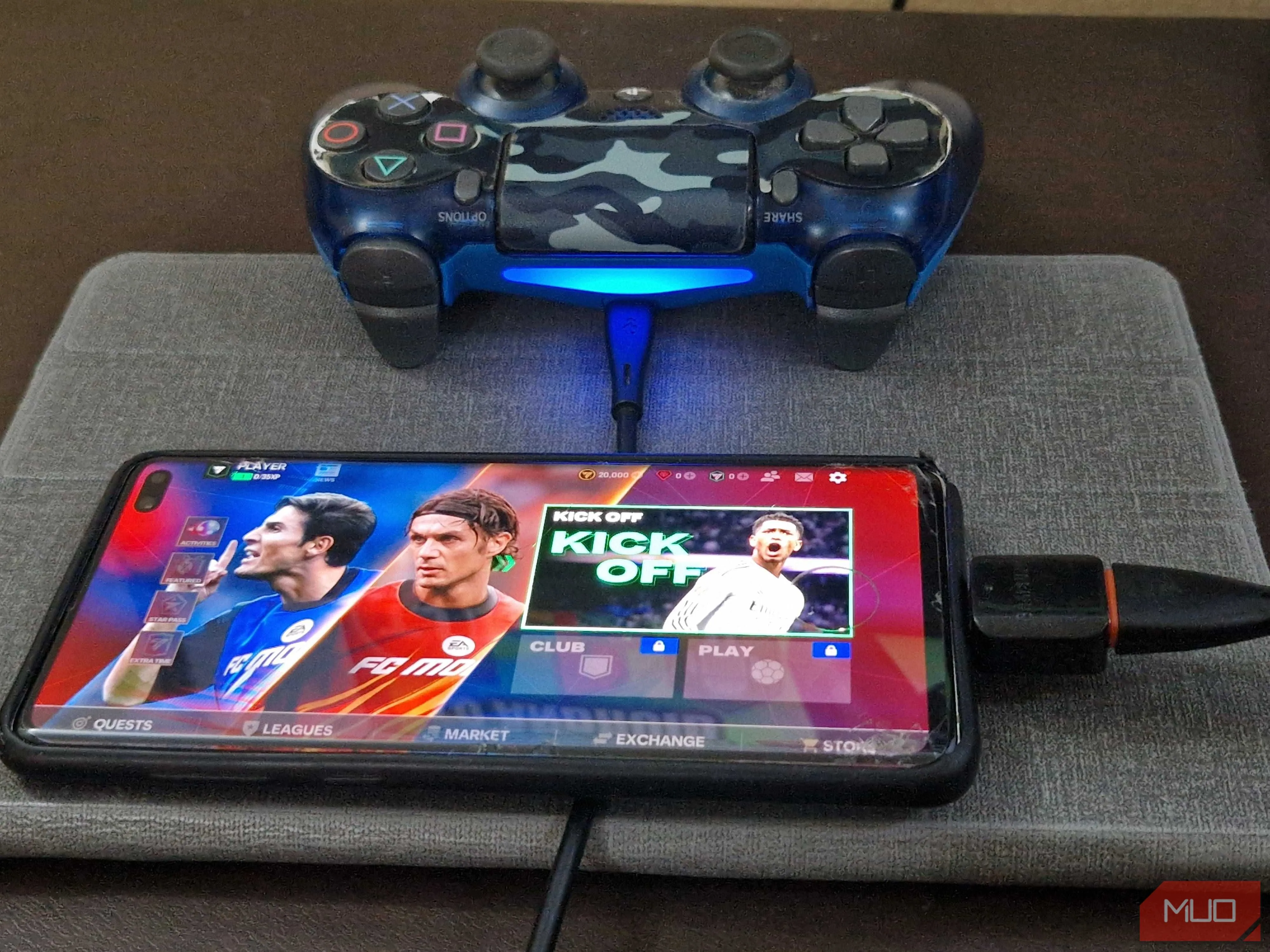 Tay cầm chơi game PS4 được kết nối với smartphone thông qua cáp USB và adapter OTG, tăng cường trải nghiệm gaming di động