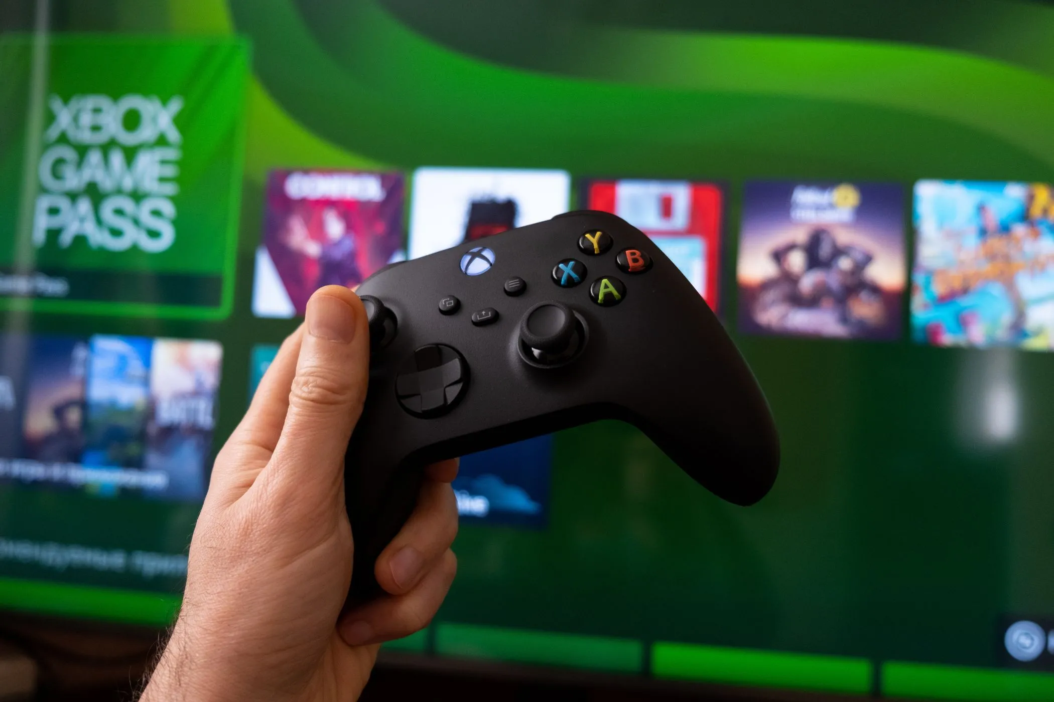 Tay cầm Xbox và màn hình hiển thị dịch vụ Xbox Game Pass, minh họa ứng dụng của định dạng âm thanh PCM trong trải nghiệm chơi game để giảm độ trễ.