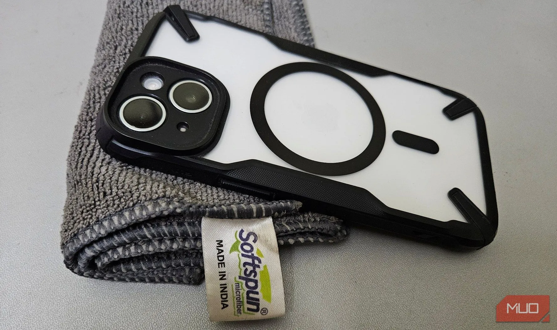 Tay người dùng đang dùng khăn microfiber để vệ sinh ống kính camera điện thoại trước khi chụp ảnh đêm