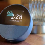 Thiết bị Amazon Echo Spot màu xanh đặt trên bề mặt gỗ, biểu tượng của sự thu thập dữ liệu đám mây của Alexa+.