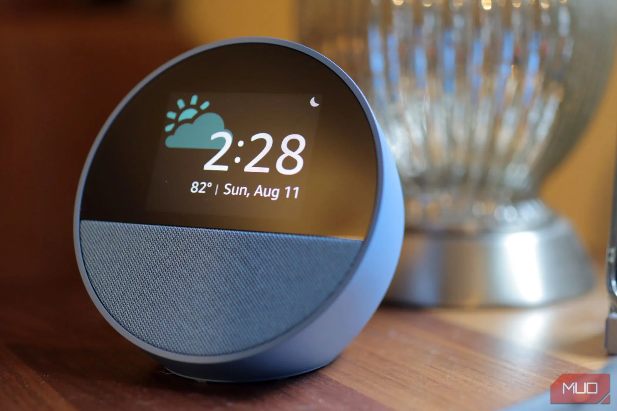 Thiết bị Amazon Echo Spot màu xanh đặt trên bề mặt gỗ, biểu tượng của sự thu thập dữ liệu đám mây của Alexa+.