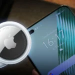 Thiết bị theo dõi Apple AirTag cạnh điện thoại Android, minh họa tính năng Google Find Nearby phát hiện thiết bị theo dõi ẩn.